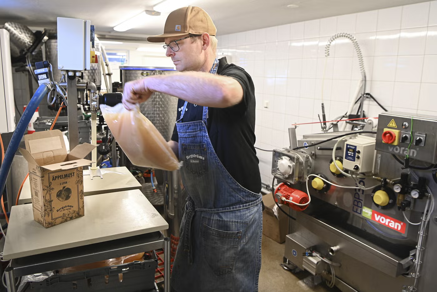 Johan fyller en bag-in-box med nypressad äppelmust i musteriet